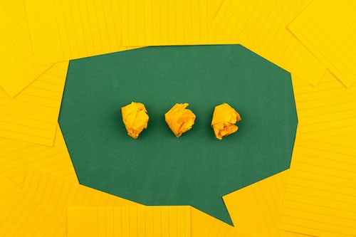 A green chat box made out of paper against a yellow background