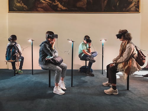 Four people in a room using virtual reality goggles