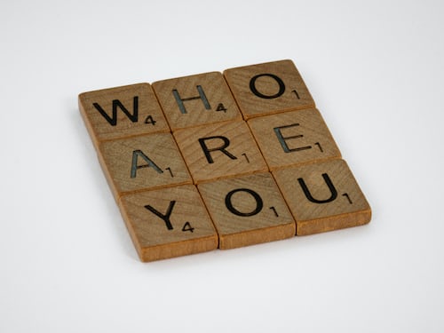 Who are you spelled out in scrabble pieces against a white background