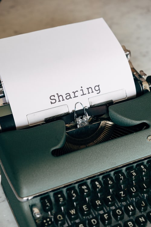 A typewriter with sharing written on a piece of paper to symbolise sharing relevant information with sales leads