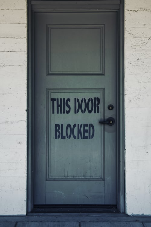 A door with this is blocked written on the front to highlight the issue of contacting C-suite decision-makers