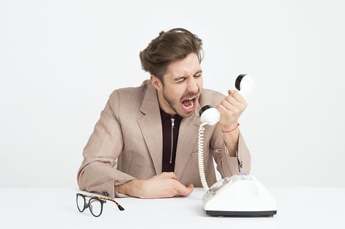 A salesman shouting into a phone during an unsuccessful cold call