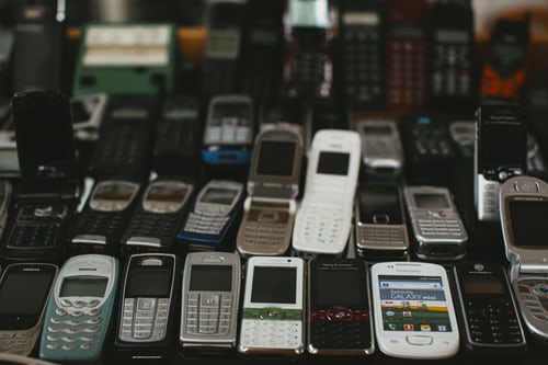 A series of old mobile phones resting on a table
