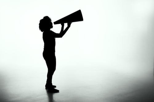 A silhouette of a lady holding a megaphone to symbolise customer contact