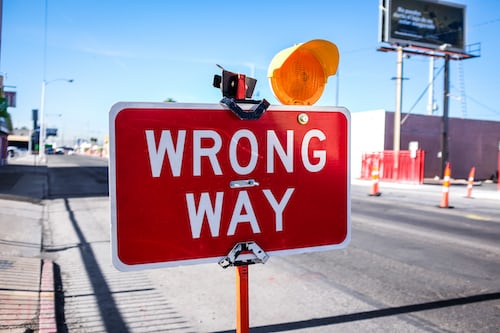 A red wrong way sign on the side of a road