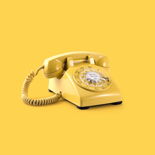 A yellow telephone against a yellow background