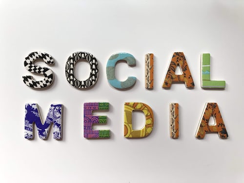 Social media spelled out inn fridge magnets against a white surface