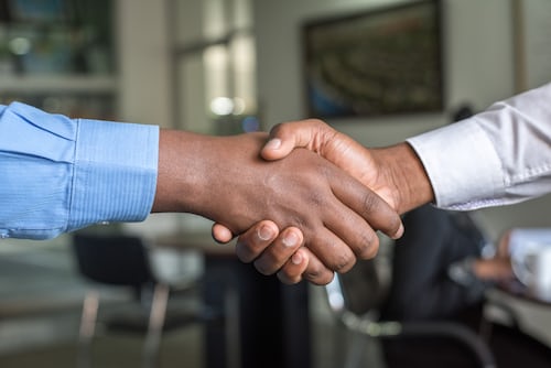 Two people handshaking after agreeing a deal about digital agency software