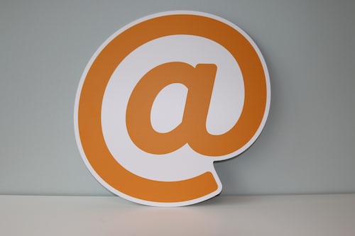 A large printed out at symbol for an email in orange
