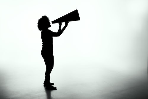 A silhouette salesperson holding a large megaphone 