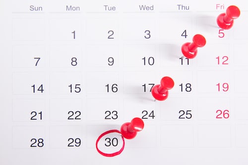 A calendar with red pins on key dates of telesales activity